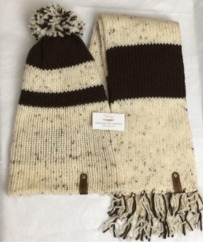 Item # 909 - Unisex Accessory - Material: 100% Acrylic Yarn, Custom Riveted Faux Leather Tags Construction: Double Layered Knit Scarf and Beanie Color(s): Aran Tweed and Chocolate Brown Size: OS Stretchable