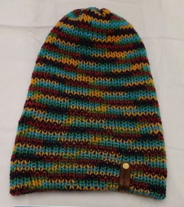Item # 2000 - Unisex Accessory - Material: 100% Acrylic Yarn / Custom Faux Leather Tag - Care: Hand Wash, Cold Water, Dry Flat - Construction: Reversible, Double Layered Knit Beanie (handmade) - Size: Adult (One Size) Stretchable - Color(s): Sky Blue and Multi-Colored Yarn - Item packed in clear resealable plastic storage bag