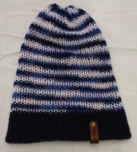 Item # 2007 Material: 100% Acrylic Yarn, Custom Riveted Faux Leather Tags Construction: Double Layered Knit Scarf and Beanie Color(s): Blue and Purple Mixed Yarn Size: OS Stretchable